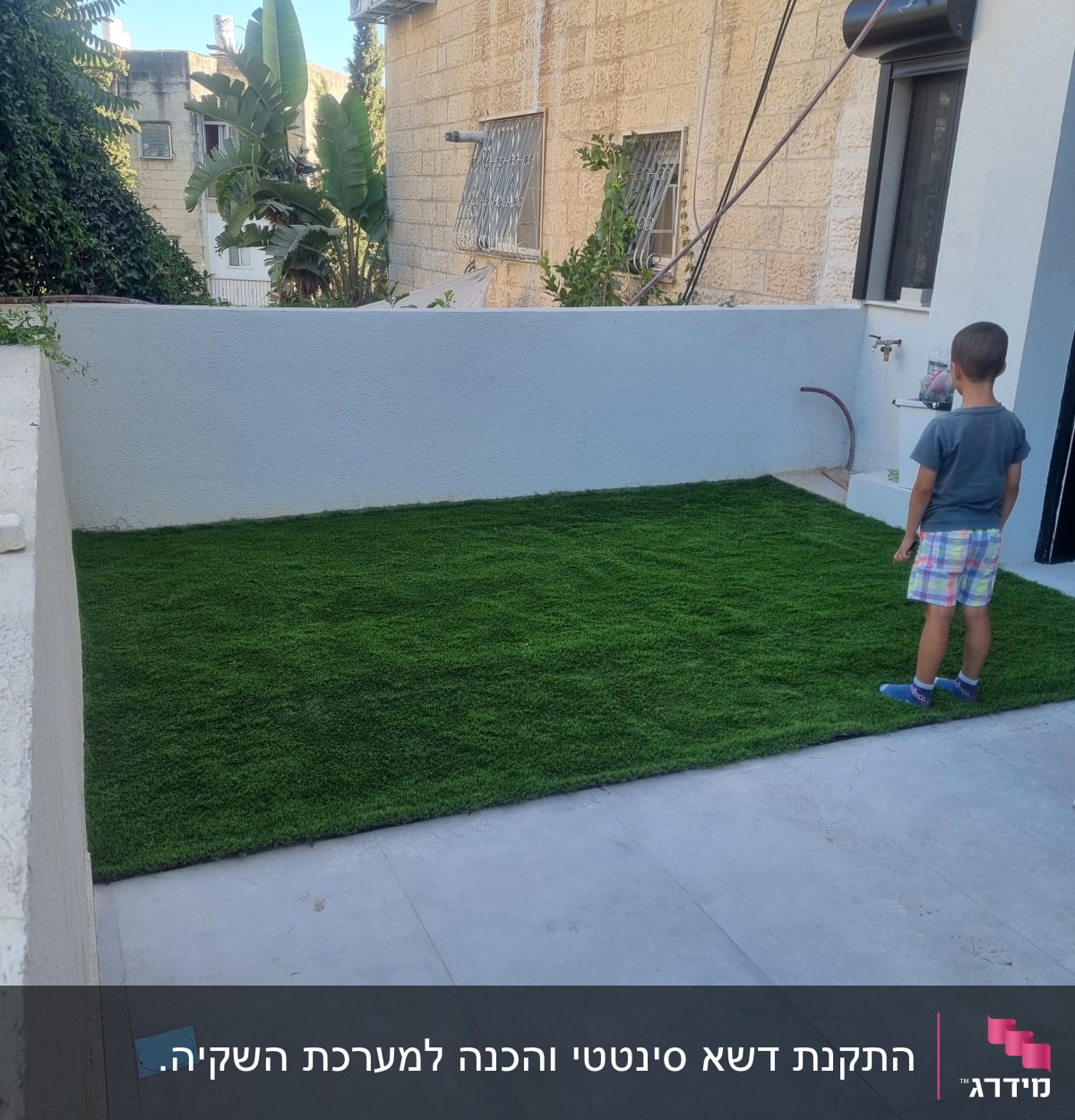 דשא סינתטי ירוק על משטח בטון בחצר קטנה